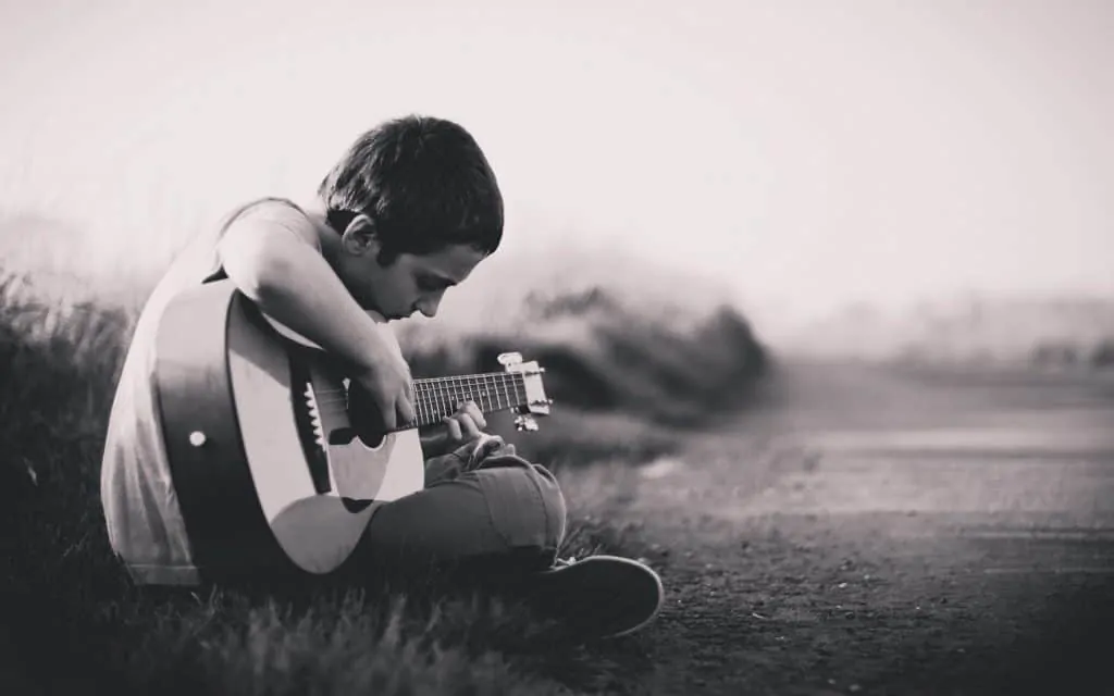 Boy playing guitar Photo by Laith Abuabdu on Unsplash