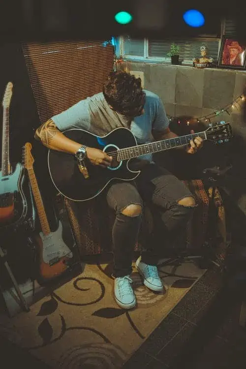 2. Guy playing guitar in chair